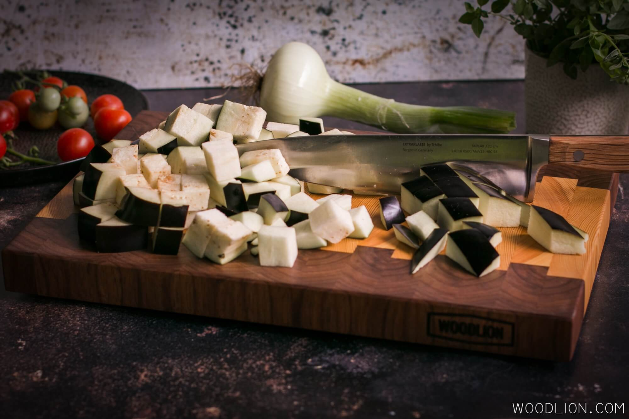 Woodlion Gastro Blog#7 - Kockázzuk fel a padlizsánt késbarát fa vágódeszkán. Tegyük a hagyma mellé, sózzuk, és fedő alatt pároljuk, míg levet enged és megpuhul.